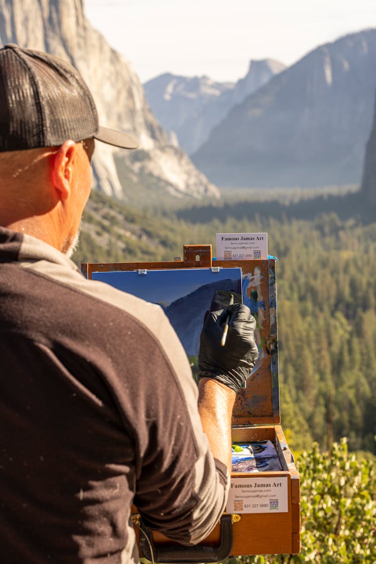 Man Painting A Scenic Mountain Landscape