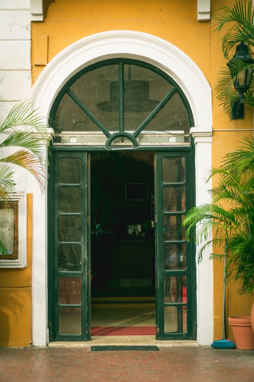 Free Elegant colonial doorway with green frame and arched design, showcasing Cartagena's vibrant architecture. Stock Photo