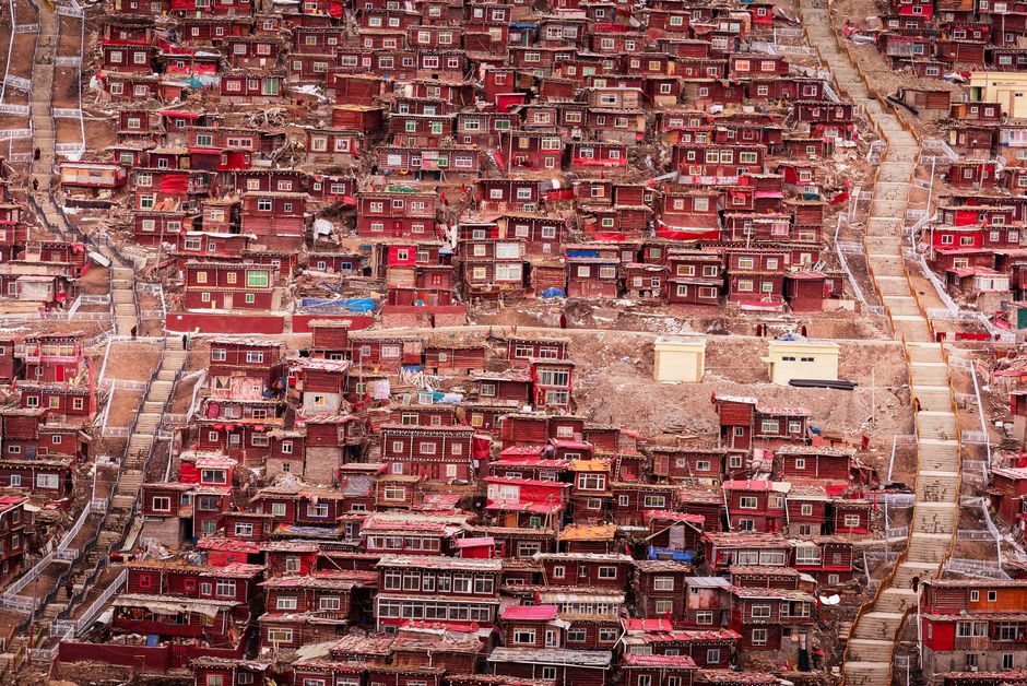 High-angle view of red houses densely packed on a hillside, forming an urban landscape.