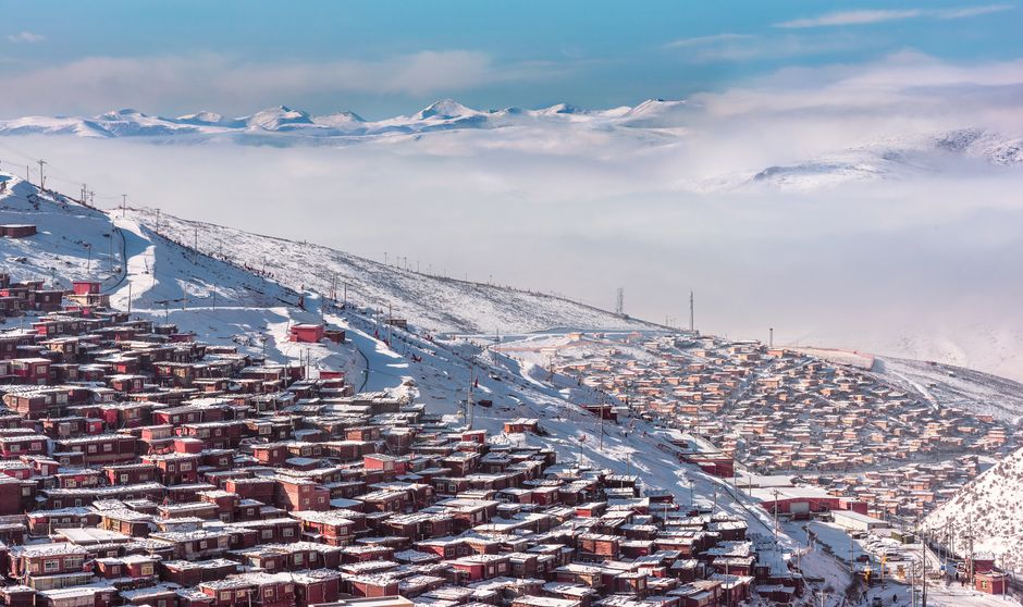 Discover a scenic aerial view of a snow-covered town nestled on a mountain, capturing the essence of winter.