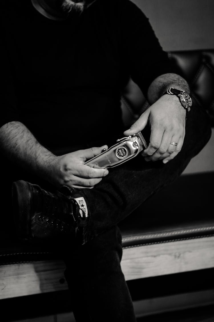 Black And White Photo Of A Man Holding A Cordless Clipper