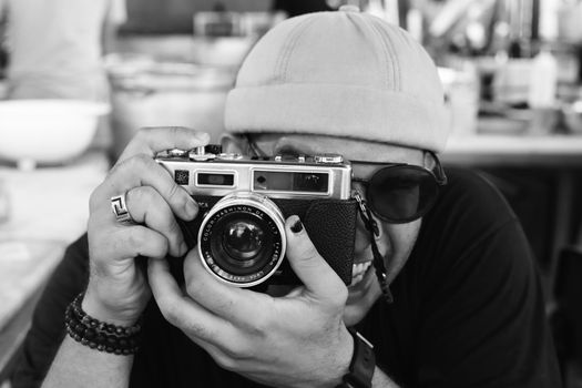 Captivating black and white image of a photographer with a vintage camera in Palermo, Italy.