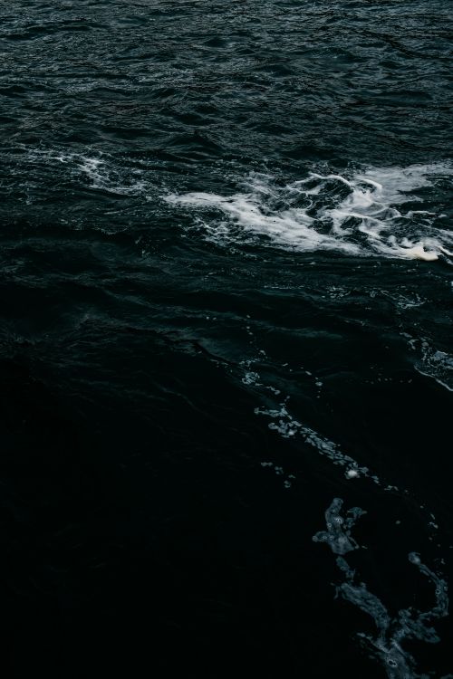 Free A moody scene of dark ocean waves with white splashes highlighting movement. Stock Photo