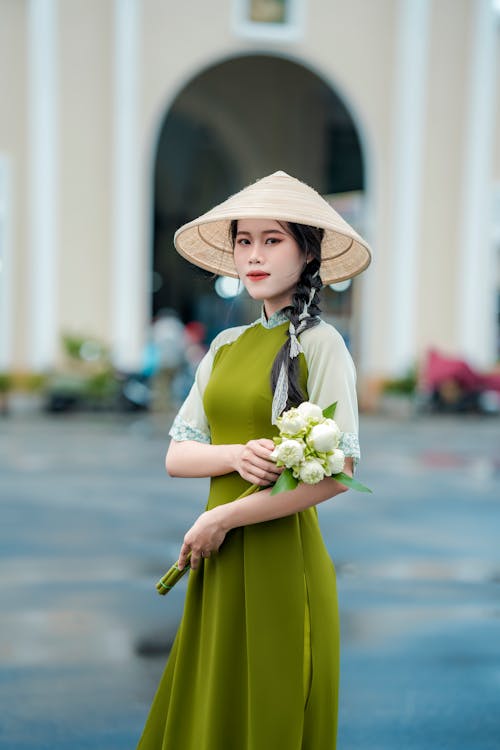 Woman in Traditional Clothing and Conical Hat