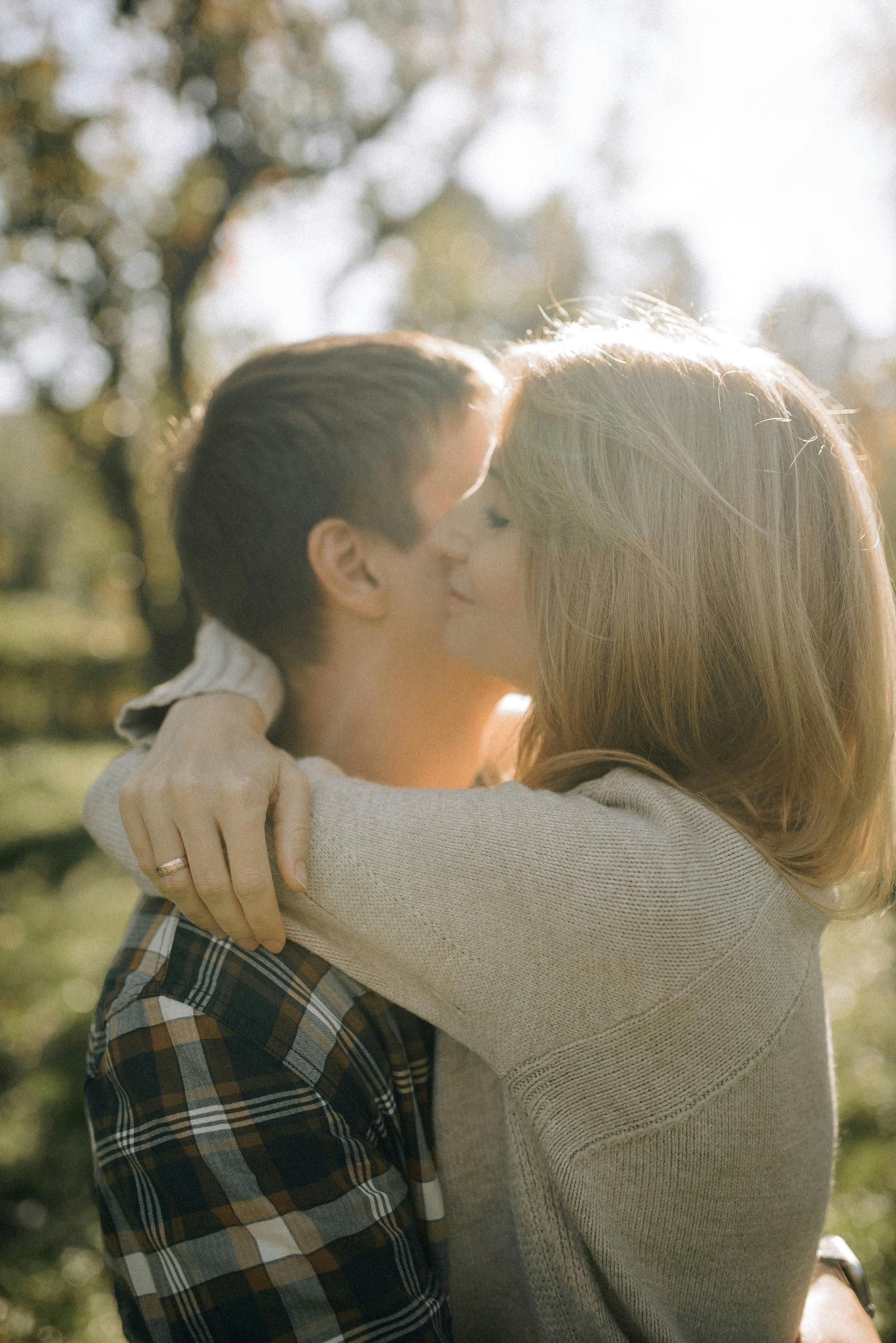 Young Couple Kissing and Embracing in a Forest · Free Stock Photo