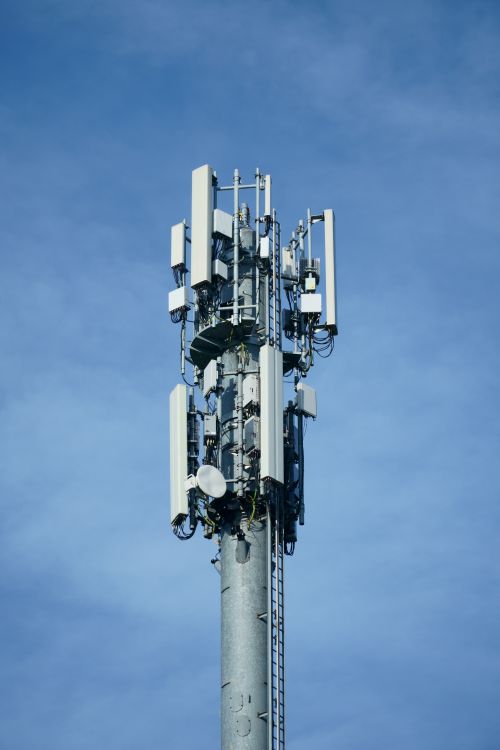 Telekomunikacijski stup s višestrukim antenama na plavom nebu
