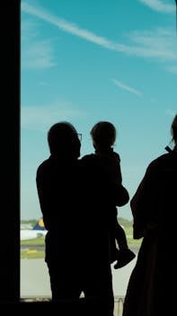 A family silhouetted against the sky at Düsseldorf Airport, Germany.