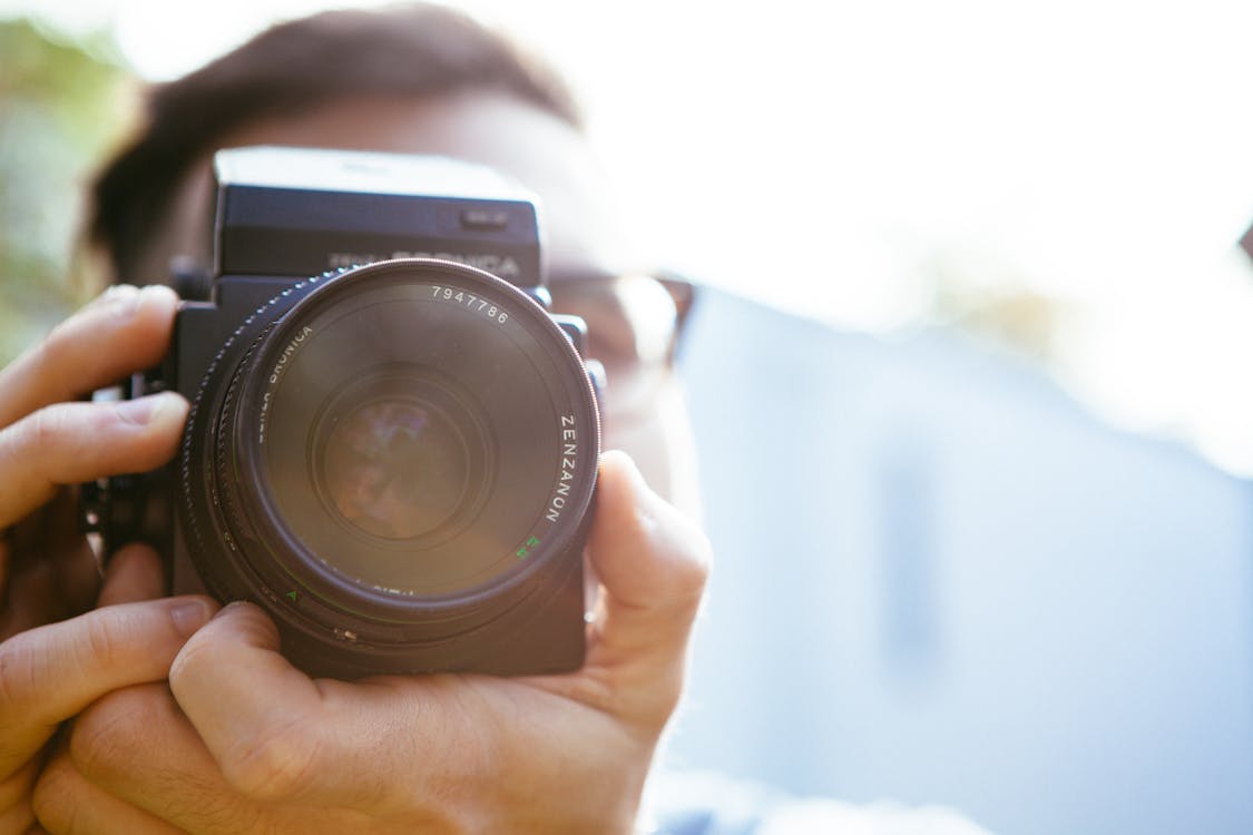 Free Person Holding Camera during Dayime Stock Photo
