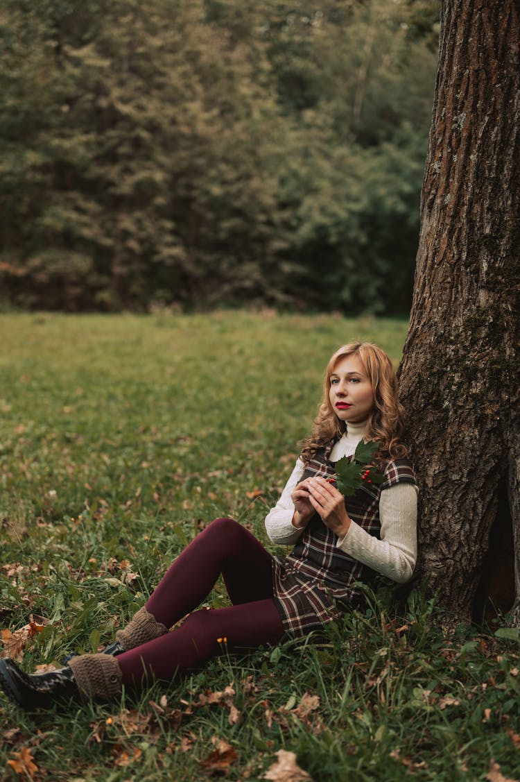 Woman Sitting Under A Tree In A Park