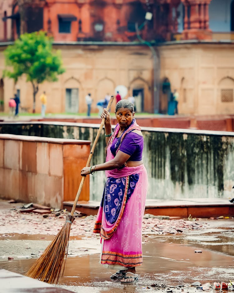 Eldery Woman Sweeping The Street 