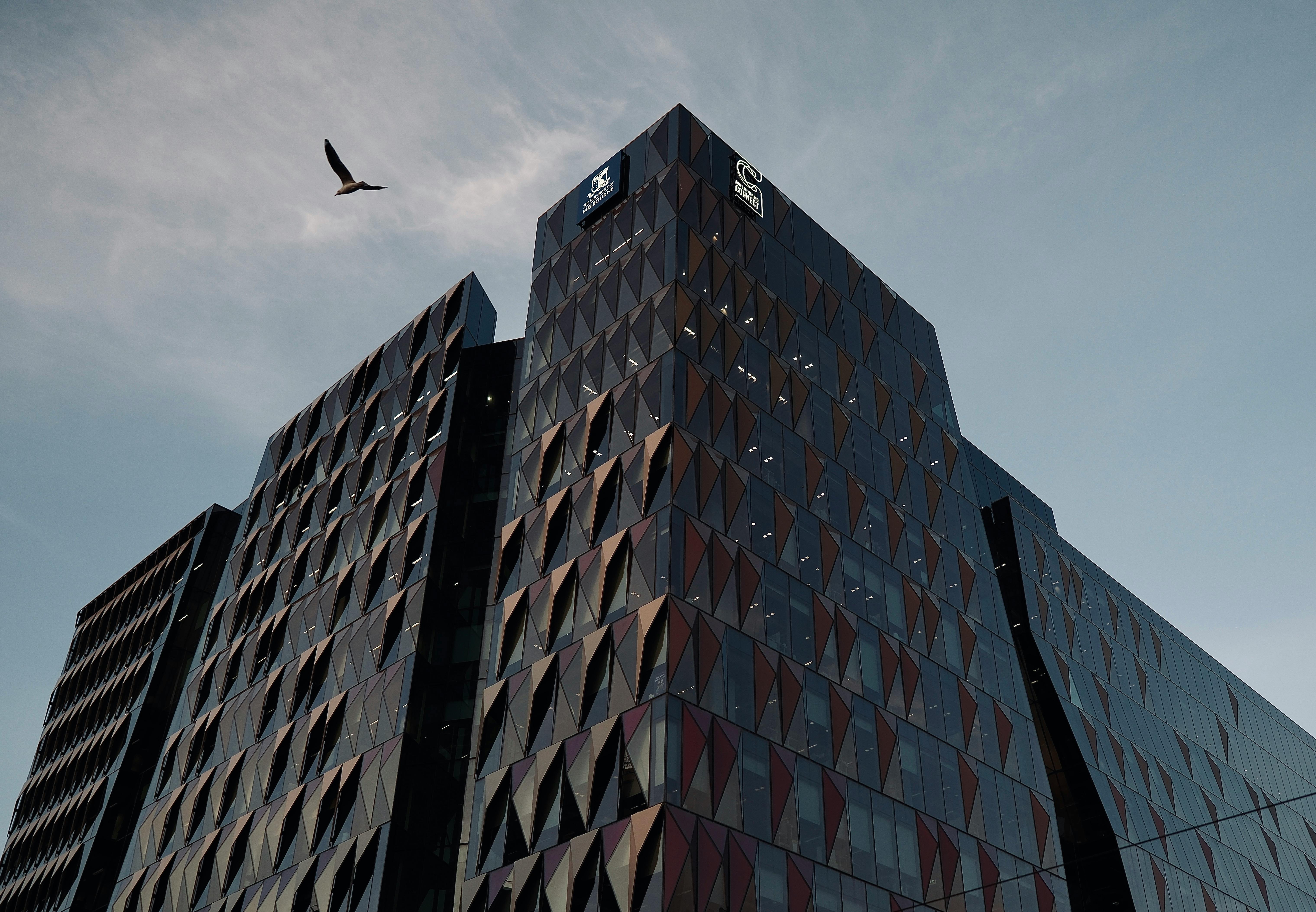 cladire moderna cu geamuri de sticla care reflecta cerul