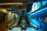 现代化室内自动扶梯上坐着人，充满活力的建筑设计