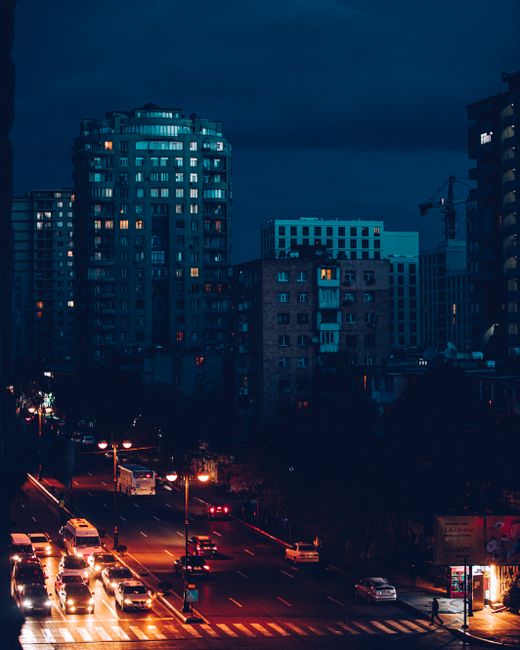 Vibrant cityscape at night with illuminated streets and tall buildings.