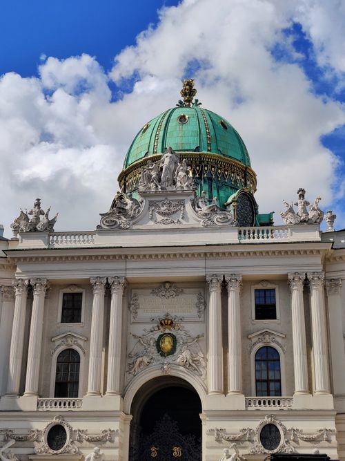 Free A stunning view of Vienna's baroque architecture featuring a grand dome against a blue sky. Stock Photo