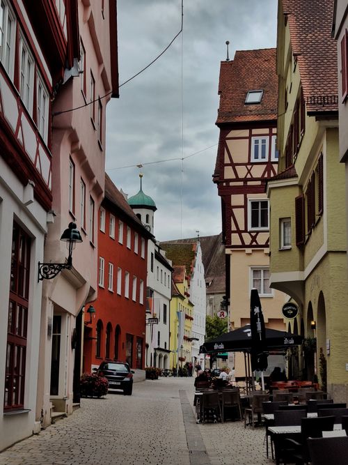 Free Quaint cobblestone street lined with colorful historic buildings in a charming European town. Stock Photo