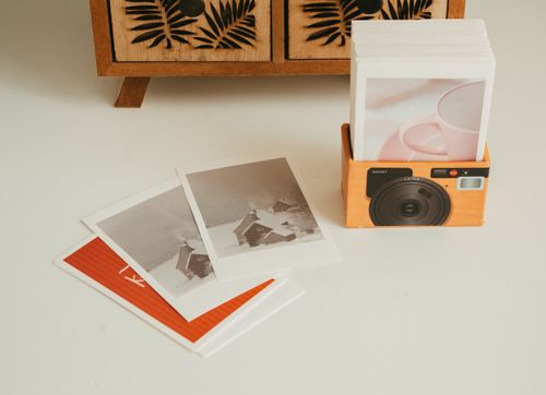 Free A collection of instant polaroid photos displayed on a wooden surface with decorative elements. Stock Photo