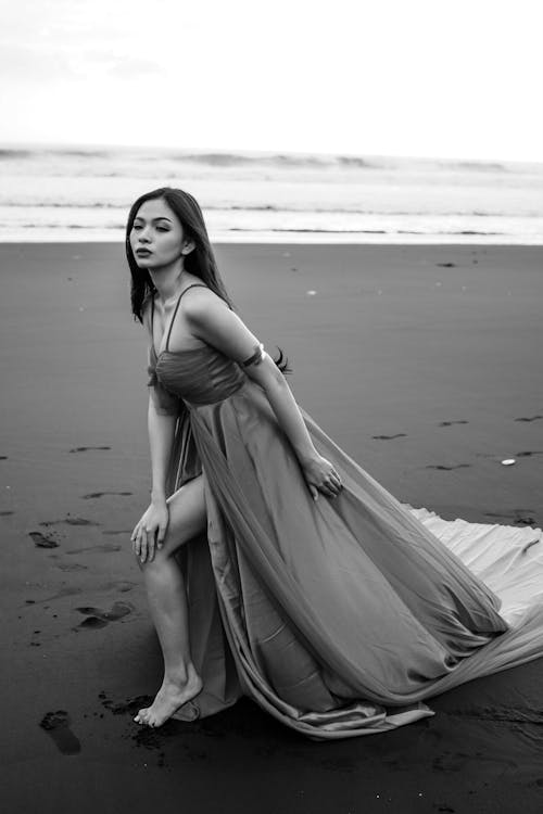 Model in a Long Evening Dress Posing on the Beach