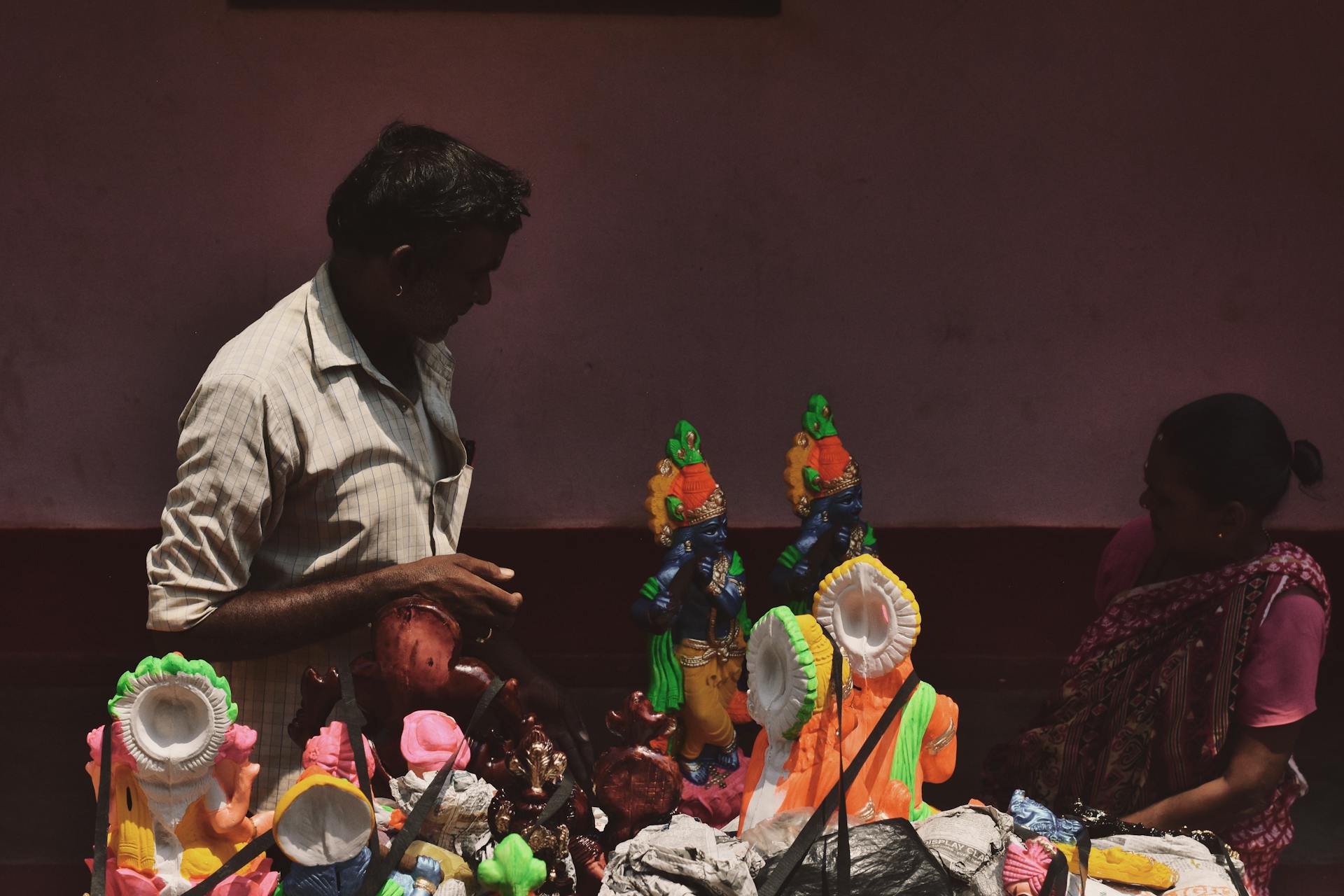 Woman and Man by Table with Gods Figurines