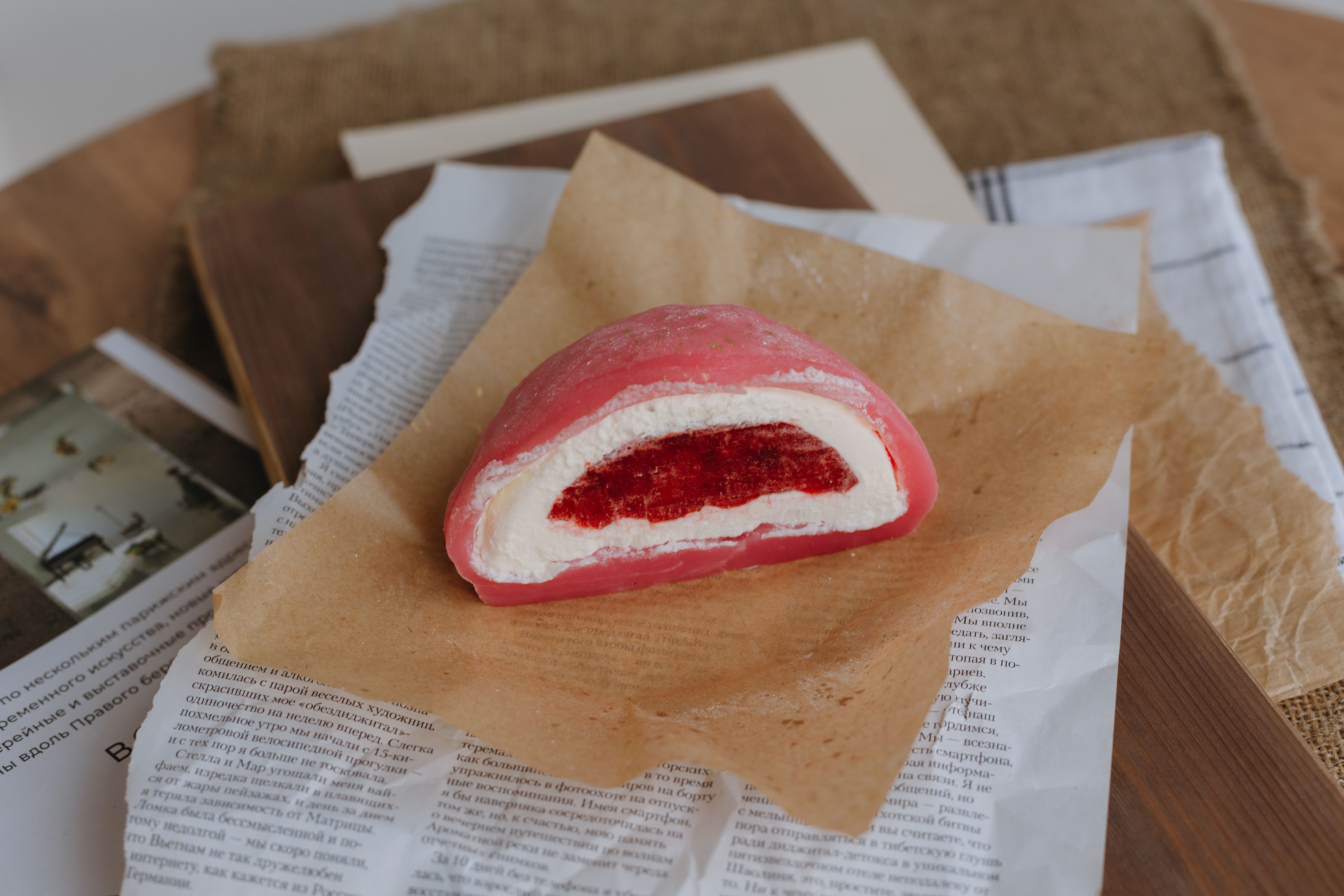Free Close-up of a pink strawberry mochi dessert on rustic paper, showcasing its texture. Stock Photo