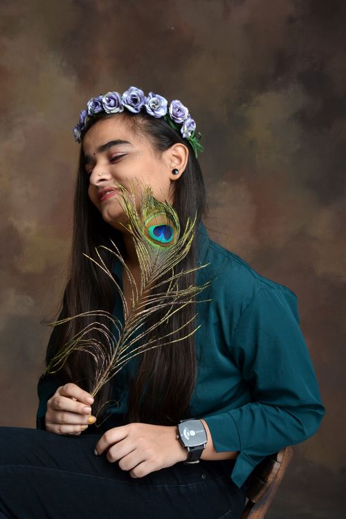 Free Portrait of an Indian woman with floral crown and peacock feather, radiating beauty and elegance. Stock Photo