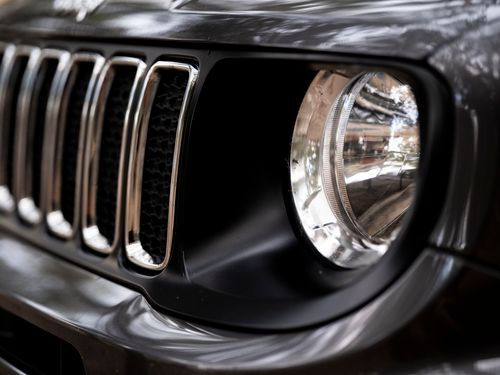 Free Detailed view of a black Jeep SUV headlight and grille, emphasizing its rugged design. Stock Photo