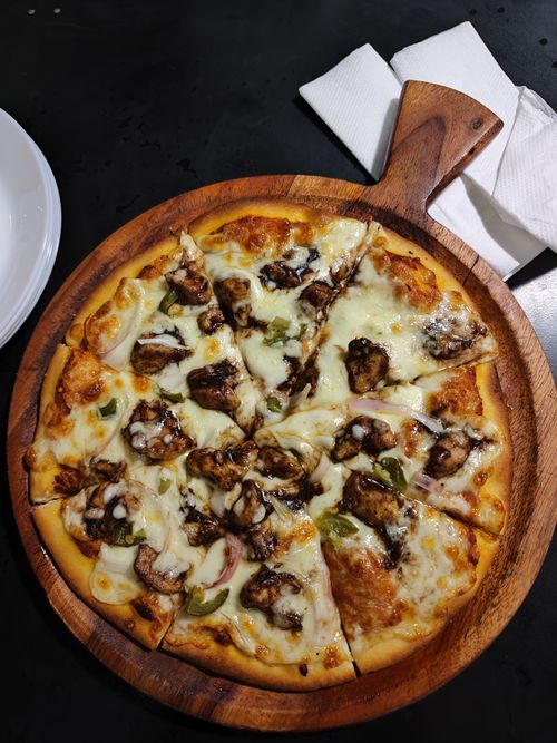 Free A freshly baked mushroom pizza with mozzarella cheese on a wooden tray, top view. Stock Photo