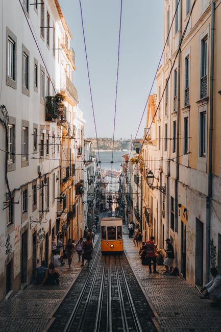 A tram travels through a narrow street in Lisbon, Portugal, showcasing its vintage charm.