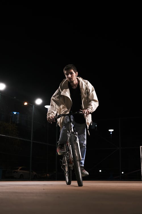 Man in Jacket on Bicycle at Night