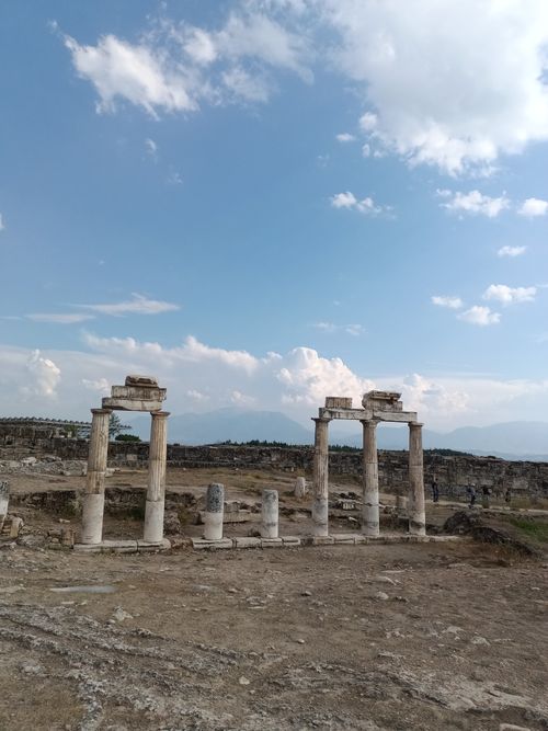 Free View of ancient ruins and columns against a clear blue sky, showcasing historical architecture. Stock Photo
