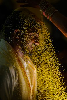 Indian bridegroom in traditional attire during a vibrant wedding ceremony.
