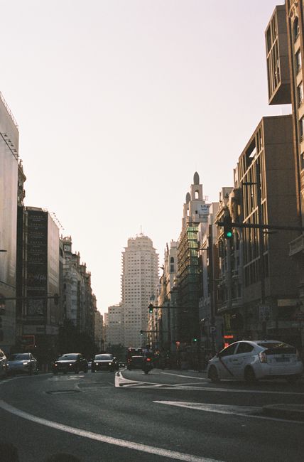 Downtown cityscape featuring bustling streets and tall buildings under a soft sky.
