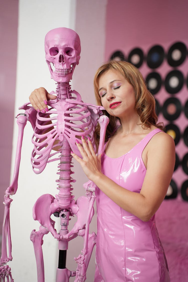 Woman In Pink Dress Hugging Skeleton