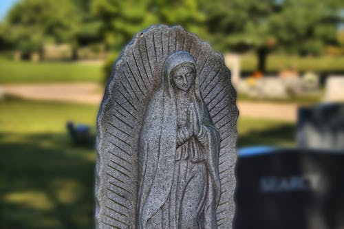 A Statue of Virgin Mary on a Cemetery