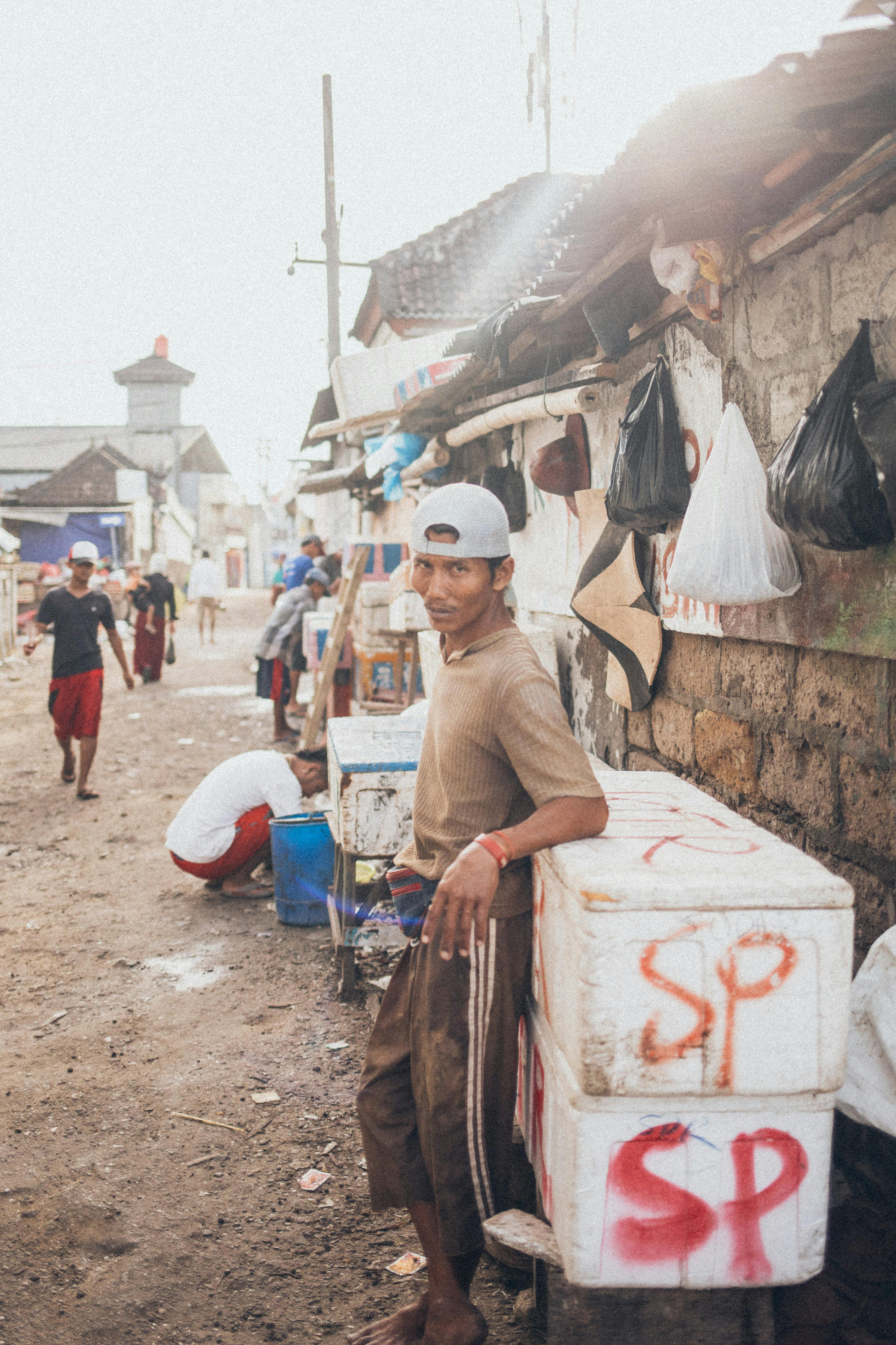 城市街景中，一名男子随意地靠在墙上