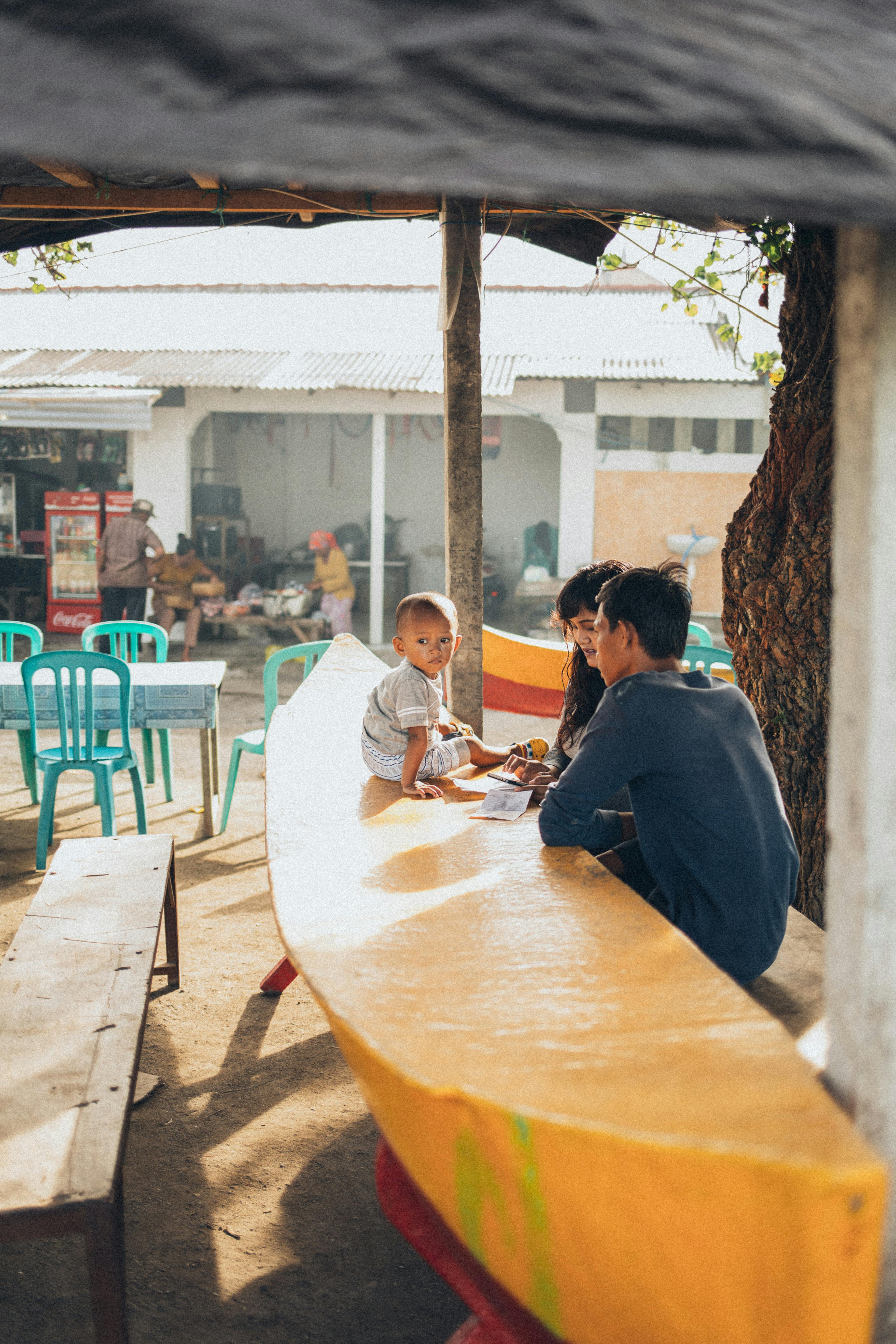 一家人坐在当地一家咖啡馆的户外遮阳棚下，度过了一个阳光明媚的日子