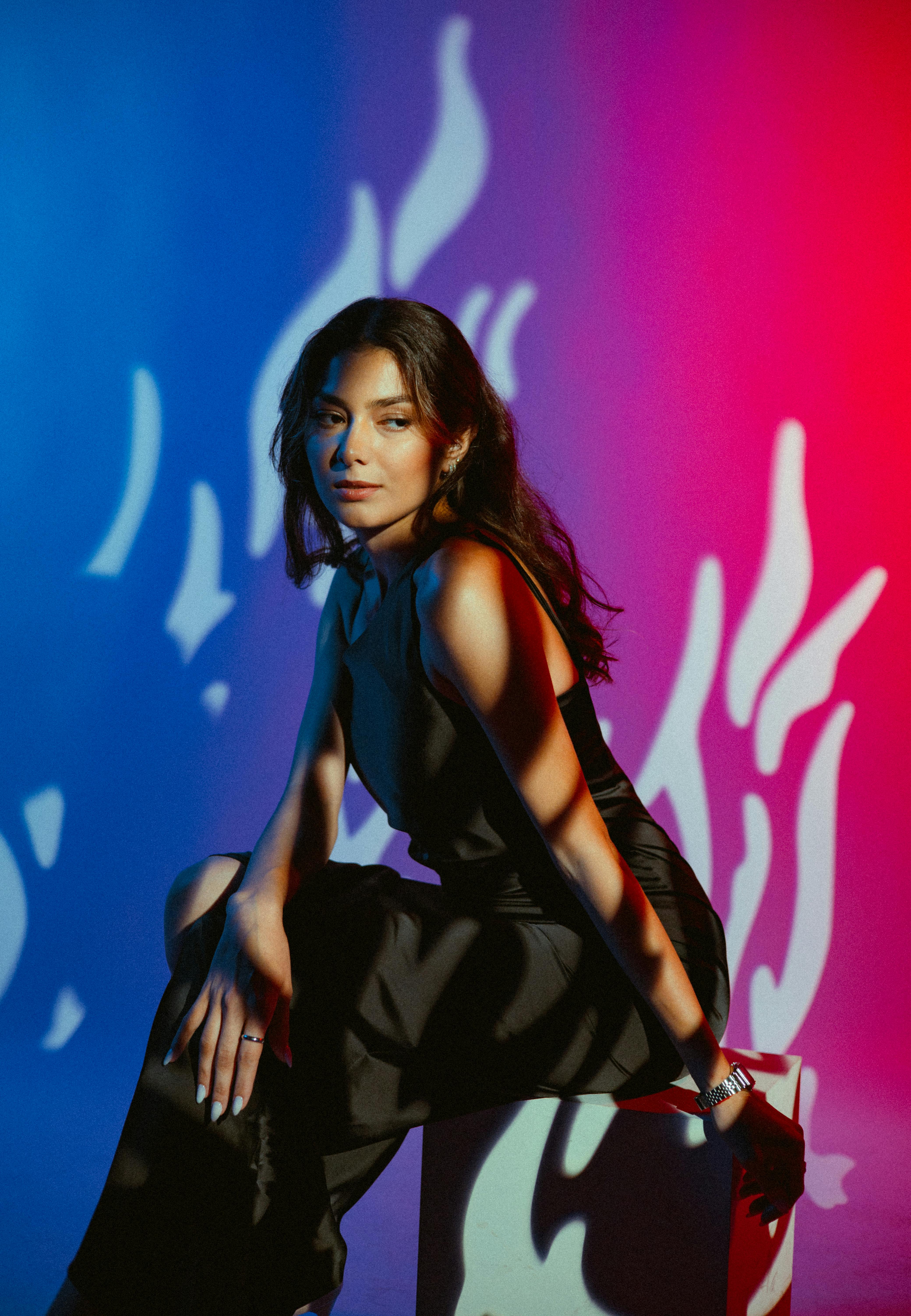 Elegant woman in dramatic lighting sitting indoors, Baku, Azerbaijan.