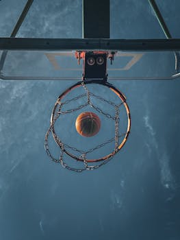 A basketball flies through the hoop set against a clear blue sky in Bakü, Azerbaijan.