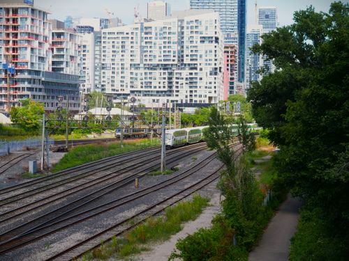 Free A vibrant view of train tracks with the Toronto skyline in the background, capturing urban life. Stock Photo