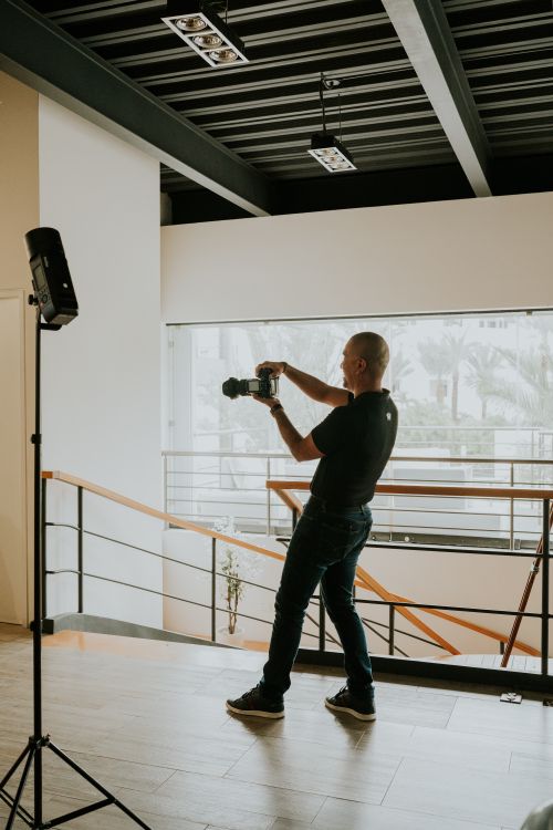 Free A photographer captures indoor scenes using a DSLR camera. Stock Photo