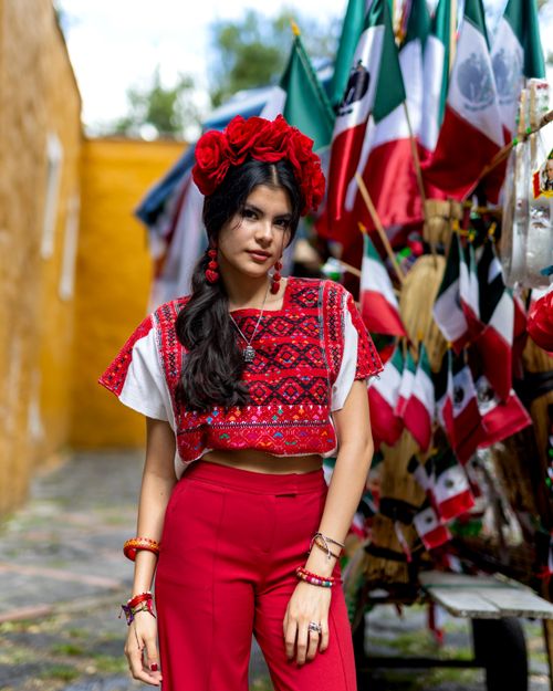 Free Vibrant portrait of a young woman in traditional Mexican attire during an outdoor festival. Stock Photo