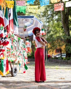 Woman in traditional Mexican costume celebrating Independence Day next to flag stall outdoors.
