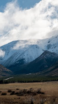 Breathtaking view of Esquel's snowy mountains with lush valley below.