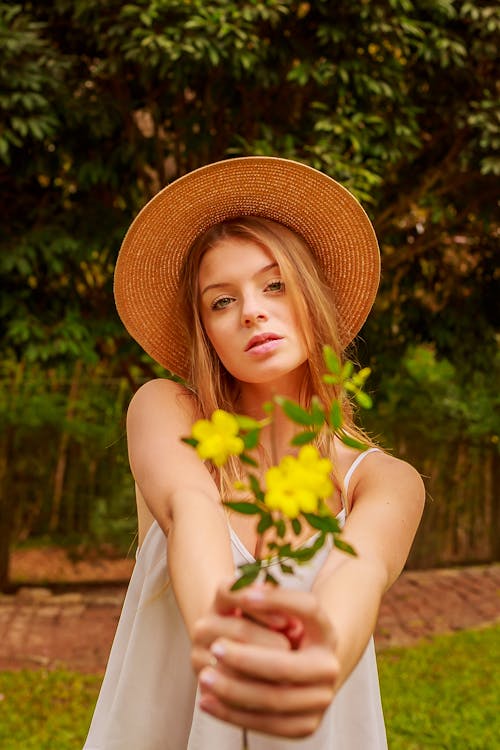 Frau, Die Blumen Mit Gelben Blütenblättern Hält