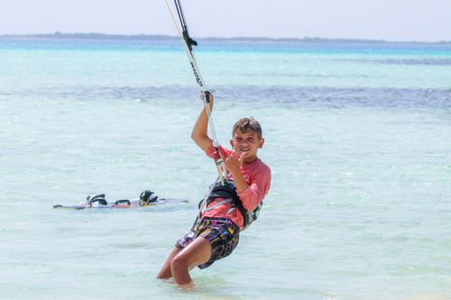 Free Teen boy enjoying kitesurfing near the shore. Perfect vacation escape. Stock Photo