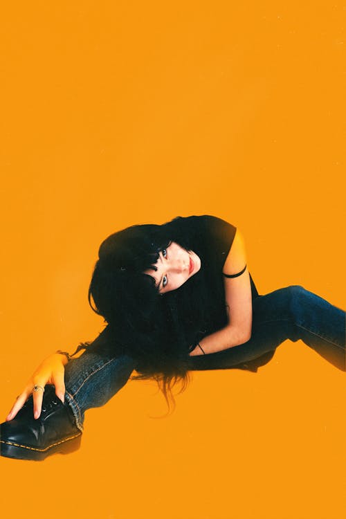 Woman Sitting and Posing on Yellow Background