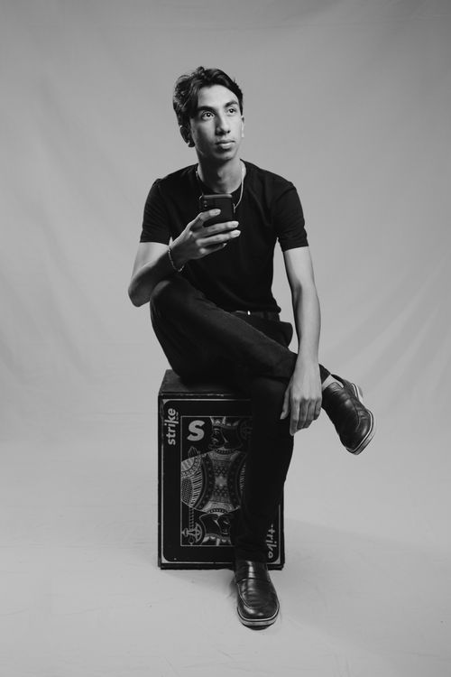 Free Stylish black and white portrait of a man seated indoors holding a smartphone Stock Photo