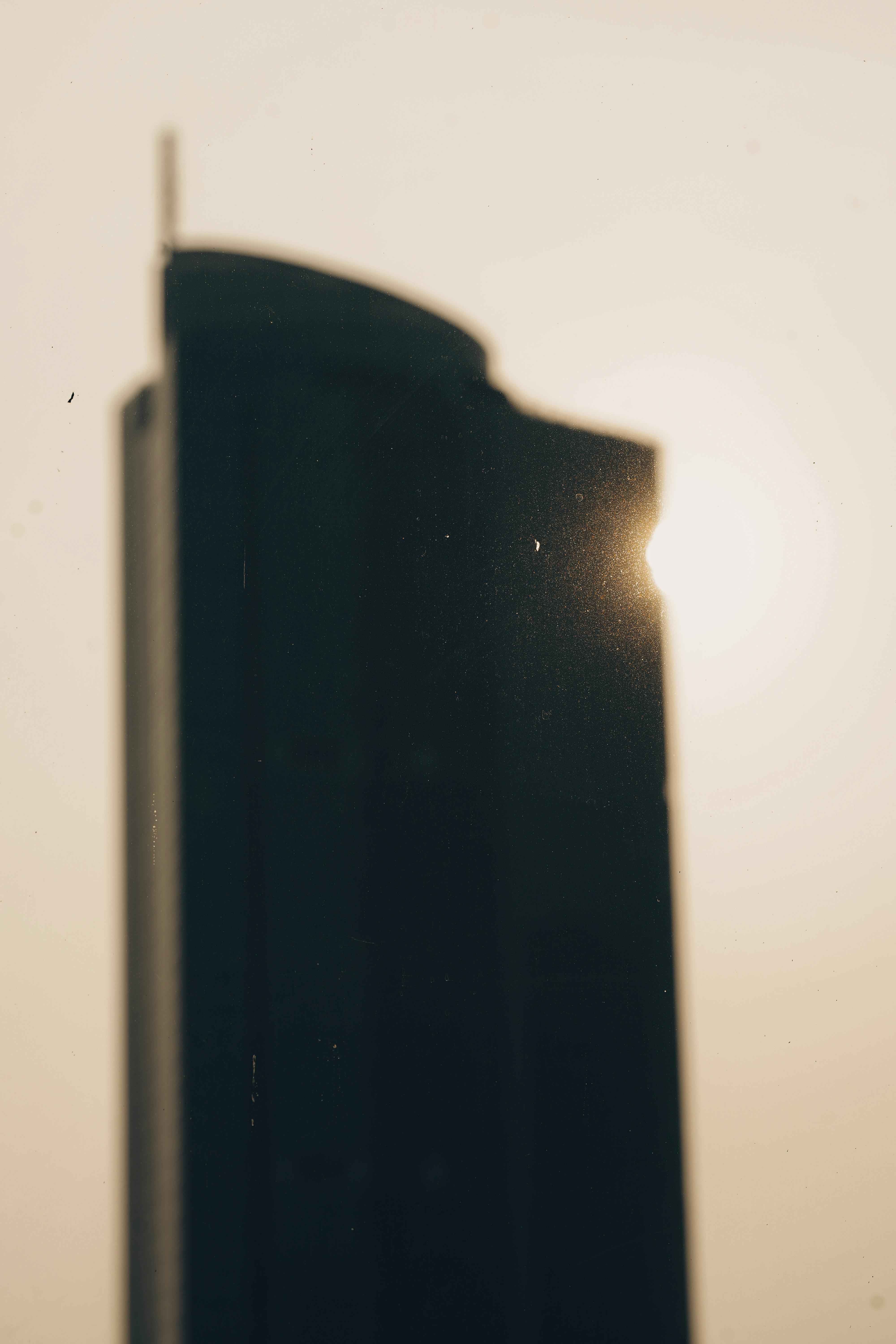 Free Blurred silhouette of a skyscraper against a setting sun in Jakarta, highlighting urban architecture. Stock Photo