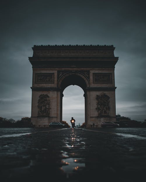 Free Motorcyclist Driving under Arc de Triomphe in Paris, France Stock Photo