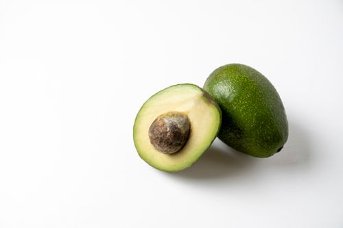 Free High-quality image of a fresh avocado cut in half with seed visible, perfect for culinary content. Stock Photo