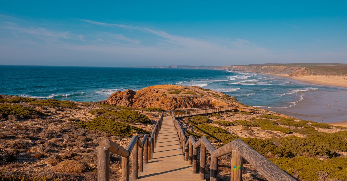 dramatic cliffs and wild Atlantic ocean waves on a golden beach in Costa Vicentina, Portugal